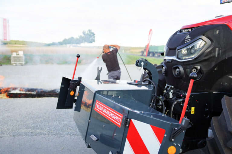Field Attack Hochdrucklöschmodul im Frontanbau an einen Traktor im Hintergrund Löscharbeiten mit Hochdruck durch einen Mann